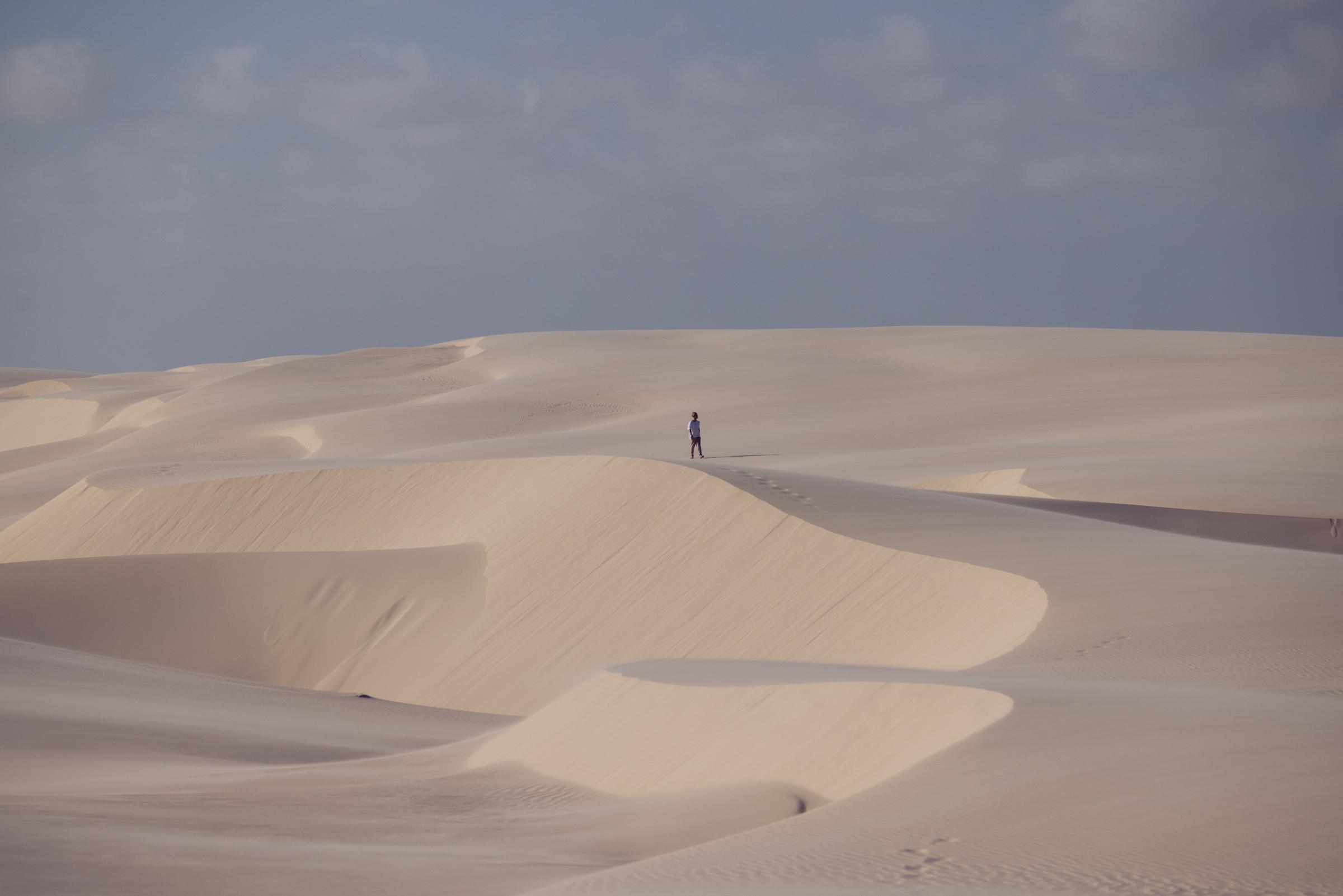 JP Castro, pequeno, no alto de uma duna imensa dos Lençóis Maranhenses